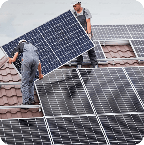 Workers installing solar panels on roof